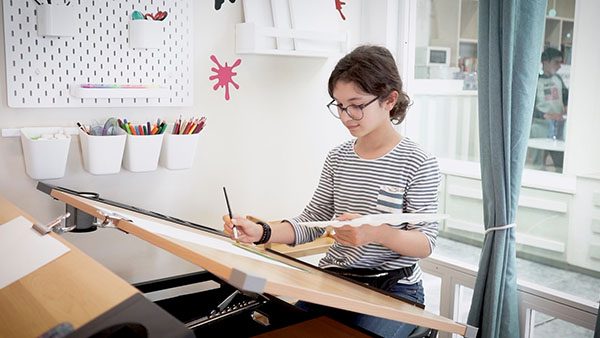 Crianças e jovens numa sala de estudo da Academia.
